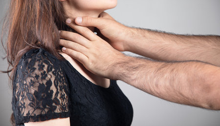 husband strangles wife on gray backgroundの写真素材