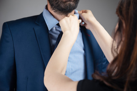 a woman straightens a man's suitの写真素材