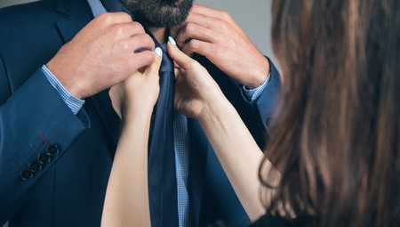 a woman straightens a man's suitの写真素材