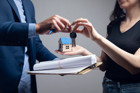 the broker gives the new owner of the house the keysの写真素材