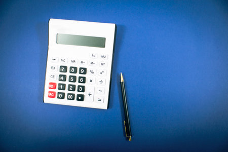calculator and pen on a blue background