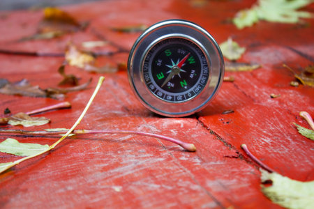 compass on a wooden table with leavesの写真素材