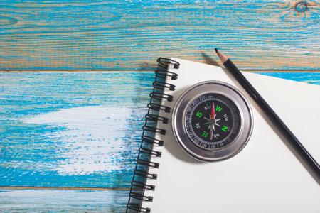 compass and pencil on notepad. travel notes concept