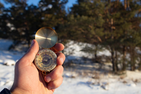 holding a compass on the background of winter forestの写真素材