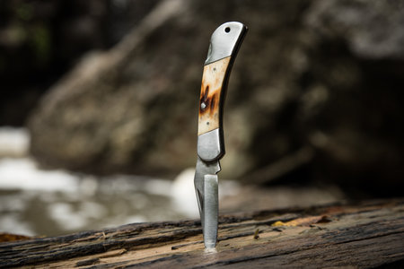 folding knife on an old brown logの写真素材