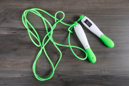 green skipping rope for training on a wooden table