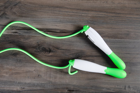 green skipping rope for training on a wooden tableの写真素材