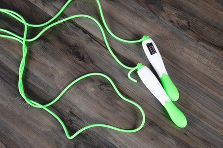 green skipping rope for training on a wooden table