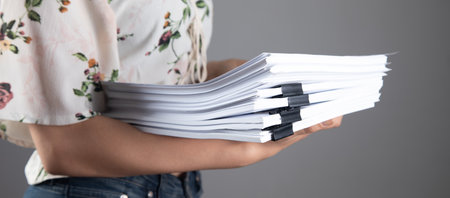 woman holding a stack of papers in her handsの写真素材