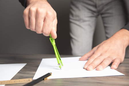 a man taking notes with a caliper on paperの写真素材