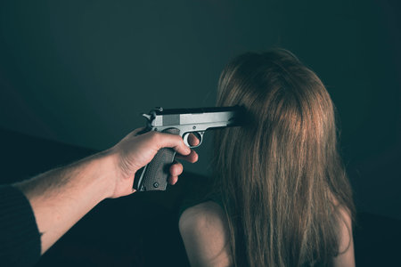 a man pointed a gun at a womanの写真素材