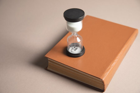 hourglass and book on the tableの写真素材