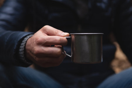 a man holding a glass in the forestの写真素材