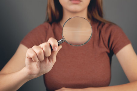 young woman holding a magnifying glassの写真素材