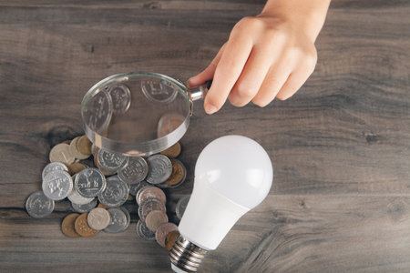 magnifier looks at coins and a light bulb