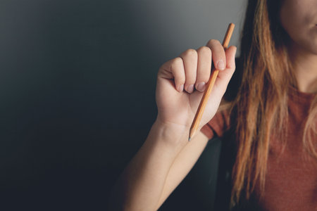 woman holding a pencil in her handの写真素材