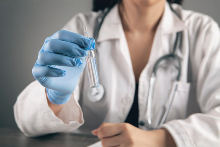 the doctor holds the vaccine at the tableの写真素材