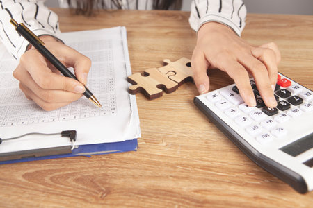 woman counts on calculator and makes notes on paper