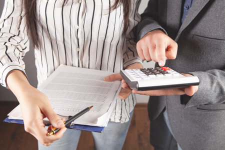businessmen check papers and count on a calculator