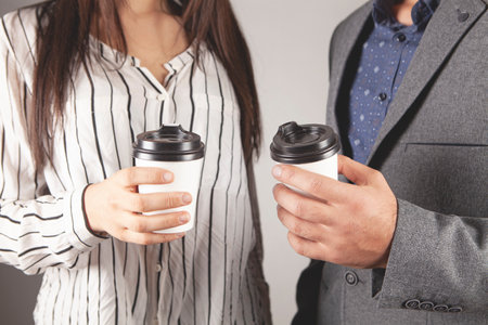 business partners are standing with a cup of coffeeの写真素材