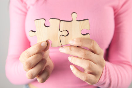 young woman holding puzzle piecesの写真素材