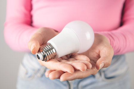 young woman holding a light bulbの写真素材