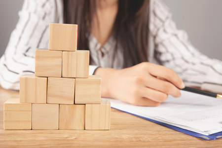 young woman sitting in front of a pyramid of cubes