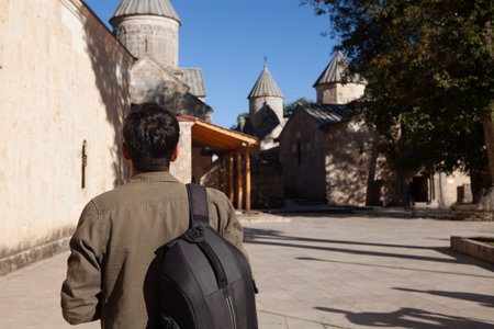 a man with a backpack stands in front of a churchの写真素材