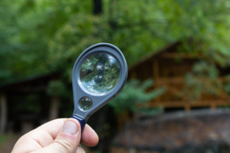 magnifying glass looking at a cabin in the woodsの写真素材