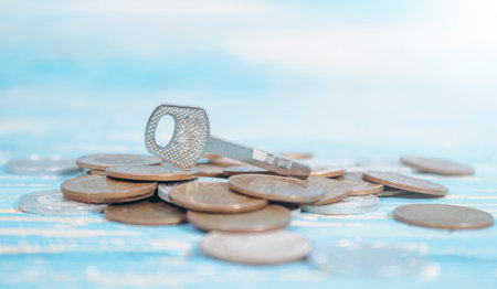 iron key and coins on the tableの写真素材
