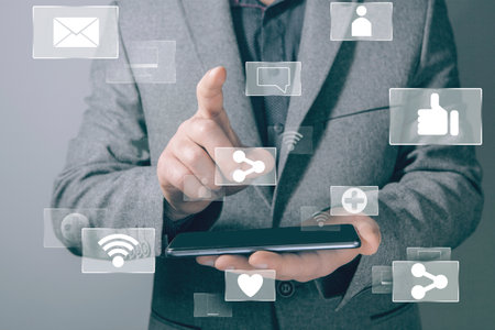 icons for social networks. like, share, wifi, computer. businessman presses the screen and holds the phoneの写真素材