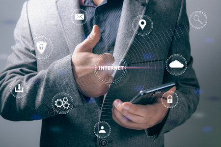 internet inscription. global network and icons. businessman holding phone and showing thumb up