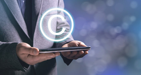 Intellectual property icon. Man holding a tabletの写真素材