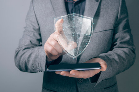 virtual shield from the network. cyber security concept. man holding phoneの写真素材