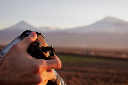 young man photographing a mountain