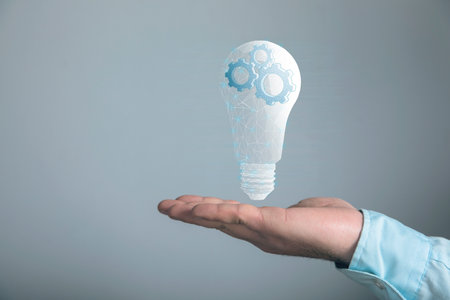 gears in a light bulb from the network. concept mechanism of ideas. Man holding in his handの写真素材