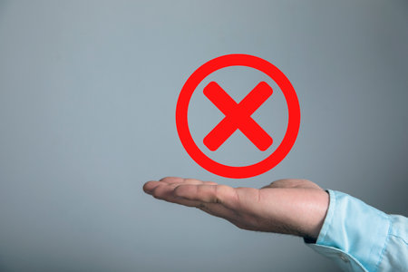 Icon red cross like cancellation. Man holding in his handの写真素材