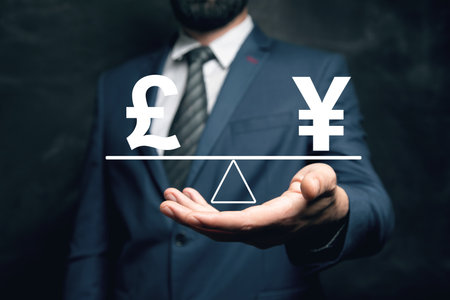 Pound and yen on the scales. Man holding in his handの写真素材