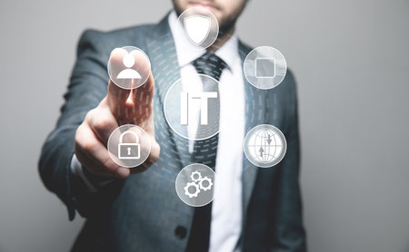IT and icons on a virtual screen. Information technology. Man tapping on the screenの写真素材