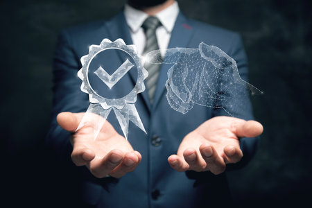 Quality assurance sign and a hand from the web. Man holding in his handの写真素材