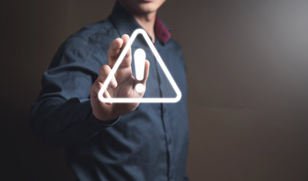 Warning sign in a triangle. Man tapping on the screenの写真素材