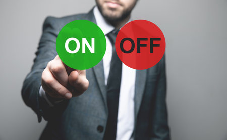 Buttons ON and OFF on a background of green and red. Man tapping on the screenの写真素材