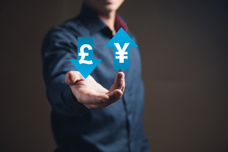 Pound and yen icons in arrows. Man holding in his handの写真素材