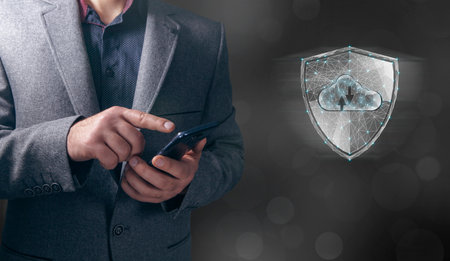 Shield and cloud storage from the web. Cyber security concept. Man tapping on phone screenの写真素材