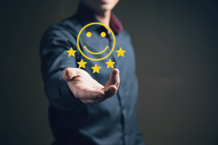 Cheerful emoticon and five stars. Businessman holding in his handの写真素材