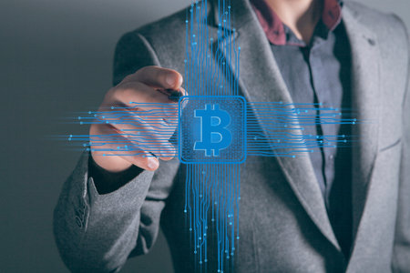 bitcoin icon in the motherboard. man tapping on the screenの写真素材