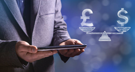 On scales Icon of dollar and pound from web. Man holding a tablet in his handの写真素材