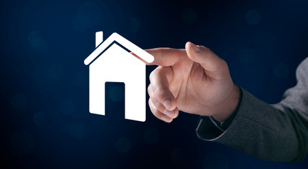 Businessman and house icon on virtual screenの写真素材