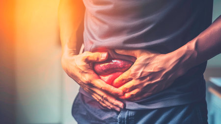 close up of man touching stomach with hands on stomachの素材