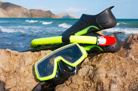 diving accessories. Mask, snorkel and flippers on the seashore on a summer sunny day.の写真素材